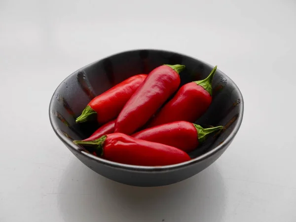 Rood hete chilis in zwarte keramische schaal. — Stockfoto