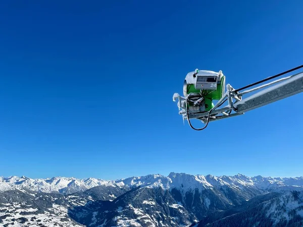 Panoramic view of green snow cannon against blue sky at skiing resort Golm, Montafon in the Austrian Alps, 12.12.2021. — Stock Photo, Image