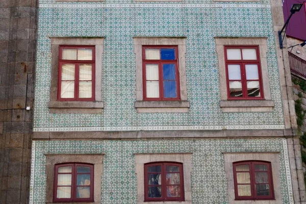 Primer plano de la fachada tradicional de la casa portuguesa con coloridos mosaicos de cerámica y ventanas rojas. — Foto de Stock