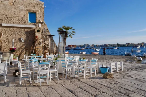 Deniz manzarası ve balıkçı tekneleri olan harika bir açık hava oturma alanı. Marzamemi, Syracuse ili, Sicilya.