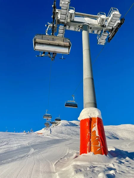 Low angle view of lift support and chairlift against blue sky. Vertical. — Stock Photo, Image