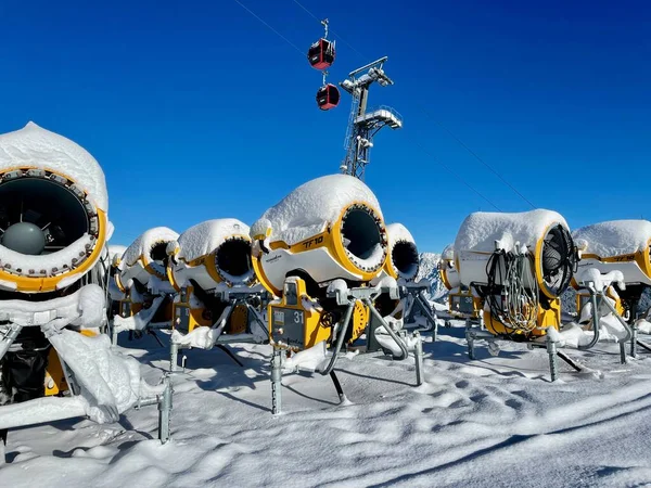 Golm, Austria, 12.12.2021. Wiele żółtych dział śnieżnych zaparkowanych w ośrodku narciarskim przed błękitnym niebem. — Zdjęcie stockowe