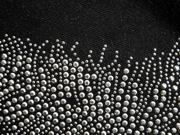 Schimmernde Perlen, Pailletten, auf schwarzer Wolle, Tapetenhintergrund. — Stockfoto