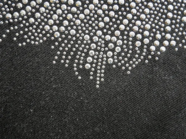Leuchtende Perlen, Pailletten, auf schwarzer Wolle, Tapetenhintergrund. — Stockfoto