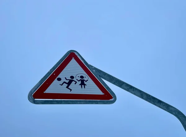 Verkeerstekens Kinderen spelen, geïsoleerd, tegen de blauwe lucht. — Stockfoto