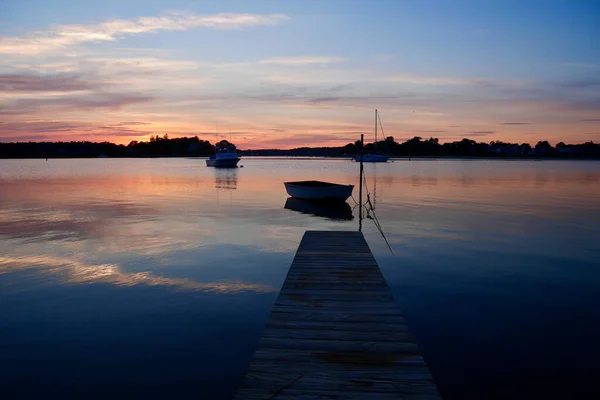 Lever de soleil dramatique sur la mer avec réflexion dans l'eau, nuages majestueux dans le ciel. Quai et bateaux à Buzzards Bay, Massachusetts, USA. — Photo