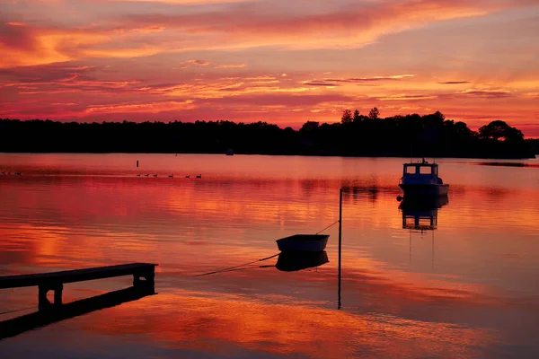 Lever de soleil dramatique sur la mer avec réflexion dans l'eau, nuages majestueux dans le ciel. Quai à Buzzards Bay, Massachusetts, USA. — Photo