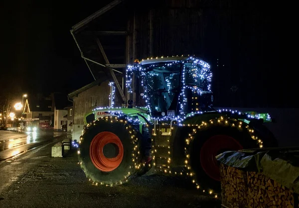 Feldkirch, Avusturya, 22.12.2019. Sokakta Noel ışıklarıyla süslenmiş çiftlik traktörü..