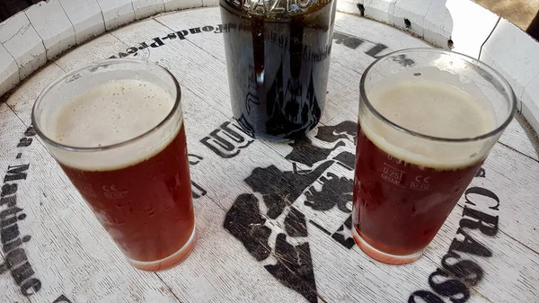 Patrimonio, Corsica, 23.08.2020. Tap beer on white wooden bar table at Ribella brewery. — Stockfoto