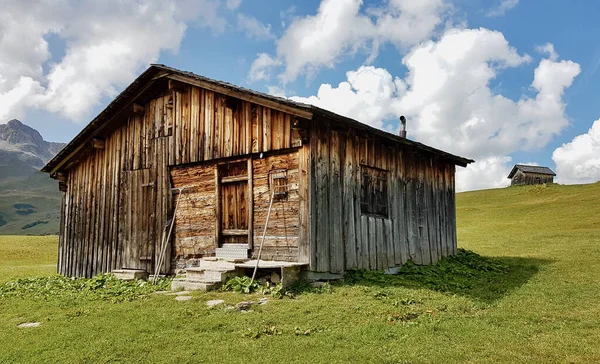 Hagyományos fából készült hegyi kunyhó az osztrák Alpokban régi gereblyével és vasvillával. Lech, Arlberg, Ausztria. — Stock Fotó