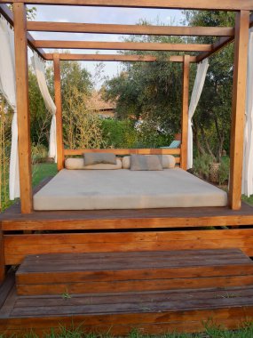 Tropikal bahçede lüks havuz kenarı yatağı. Seyahat, tatil konsepti.