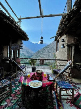 Muhteşem Toubkal manzaralı enfes Fas kahvaltısı. Yüksek Atlas Dağları 'ndaki Berber evinde çok güzel dekore edilmiş çatı terası. Imlil Vadisi, Fas.