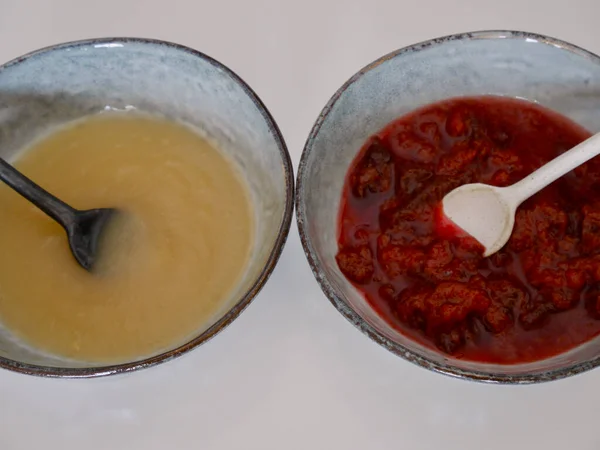 Zbliżenie domowej roboty sos jabłkowy i śliwka pieczeń na skandynawskich talerzach ceramicznych, białe tło. — Zdjęcie stockowe