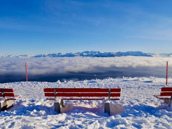 Hoher Kasten teleferiğinin dağ istasyonunda kışın Avusturya Alpleri manzaralı kırmızı banklar. Alpstein, Appenzell, İsviçre. — Stok fotoğraf