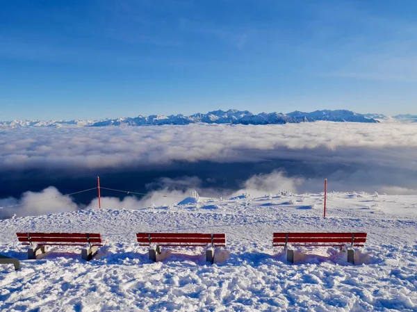 Hoher Kasten teleferiğinin dağ istasyonunda kışın Avusturya Alpleri manzaralı kırmızı banklar. Alpstein, Appenzell, İsviçre. — Stok fotoğraf