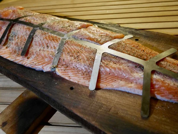 Raw piece of salmon fillet on wooden board, ready to be flame grilled on open fire. — Zdjęcie stockowe