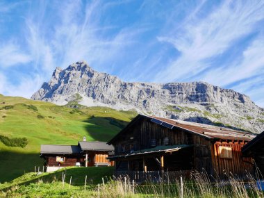 İsviçre Alp Köyü 'nün arka planında Sulzfluh olan geleneksel ahşap dağ kulübeleri. Praettigau, Graubuenden, İsviçre.