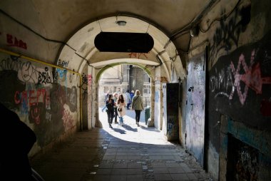Lviv, Ukrayna, 9.04.2019. İnsanlar tarihi bir kasabada bir geçitten geçiyorlar..