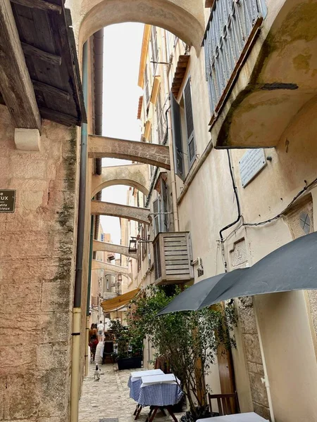 Bonifacio, Corsica, 26.07.2021. Narrow alleyway with restaurant tables in the picturesque old town of Bonifacio. — Stockfoto