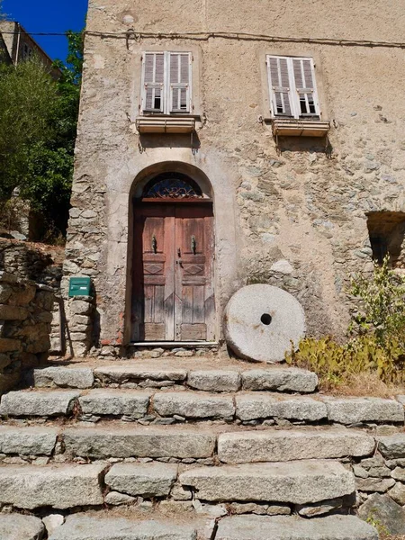 Old stone house with millstone in Lama, a dreamy hilltop town nestled in the mountains. Corsica, France. — Fotografia de Stock