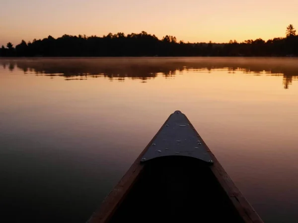 Front of canoe on peaceful Ox lake at sunrise. Minnesota, the Land of 10000 lakes, USA. — Fotografia de Stock
