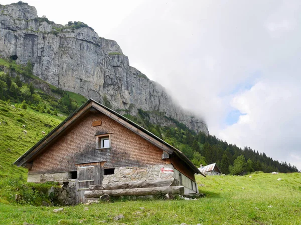 Traditional mountain hut in front of rock face. Alpstein, Switzerland. — ストック写真