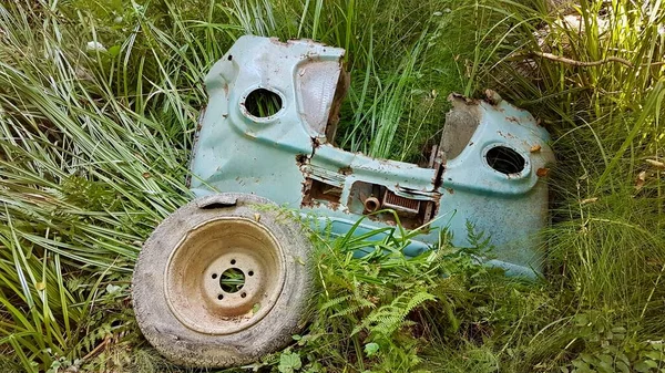 Rusty abandoned spare parts of turquoise vintage van in green nature. Corsica, France. — стоковое фото