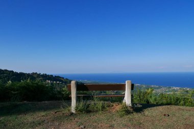 Bench in Castagniccia mountains overlooking Costa Verde and Mediterranean Sea. Corsica, France.