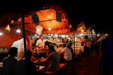 Marakeş, Fas, 24.09.2020. İnsanlar geceleri Djemaa El Fna, Marakeş, Fas meydanındaki açık büfelerde yemek yiyor. Yüksek kalite fotoğraf