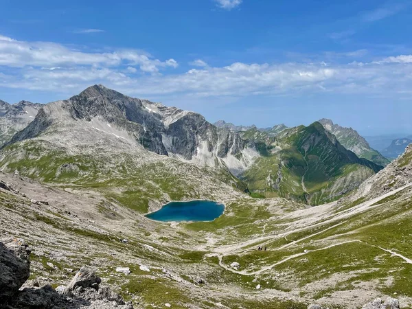 Trilha de caminhadas sinuosa através da bela natureza que leva ao Butzensee verde-esmeralda na região de Arlberg, perto de Lech. Vorarlberg, Áustria. — Fotografia de Stock