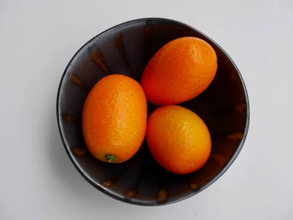 Vista Aérea Kumquats Cumquats Tigela Cerâmica Preta Contra Fundo Branco — Fotografia de Stock