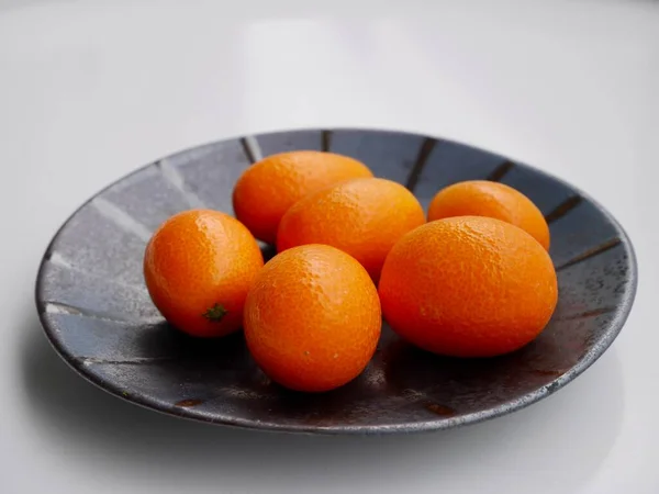 Großaufnahme Von Kumquats Kumquats Auf Schwarzem Keramikteller Vor Weißem Hintergrund — Stockfoto