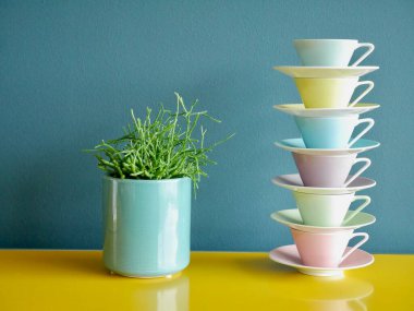 Renkli kahve fincanları yığını ve sarı masadaki tencerenin içinde benzin zeminine karşı sulu. Yüksek kalite fotoğraf