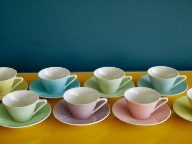Sarı masadaki pastel kahve fincanlarıyla benzin zeminini karşılaştırdım. Öğleden sonra kahve partisi. Yüksek kalite fotoğraf