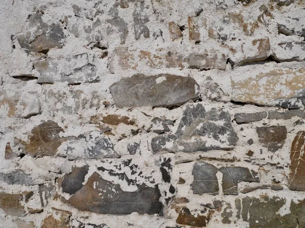 Gros plan de la vieille façade de la grange. Mur de pierre avec du plâtre blanc qui s'effrite. — Photo