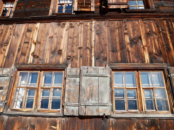 Fenster mit Fensterläden eines sehr alten verwitterten hölzernen Bauernhauses. — Stockfoto