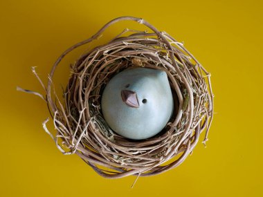 Sarı arka planda söğüt yuvasında seramik Paskalya tavuğu. Yüksek kalite fotoğraf