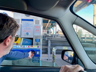 Milan, Italy, 19.04.2022. Man paying with card at toll station on Italian highway. High quality photo