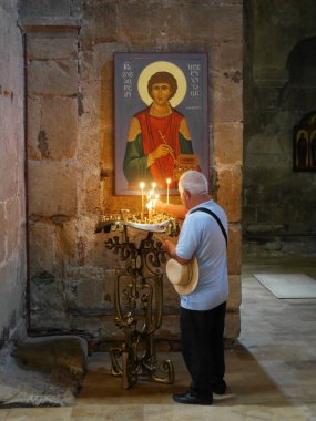 Svetitskhoveli Katedrali, Mtskheta, Gürcistan 'da mum sunan adam, 27.07.2022. Yüksek kalite fotoğraf