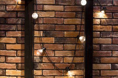 Ampul lambalı eski kahverengi tuğla duvar. Çatı katına bir Edison lambası da dahil. Eski kahverengi tuğla duvar arkaplanının dokusu.