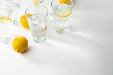 Su kopyalama alanı. Su camı fon. Bardaklı maden suyu yansımaları. Beyaz masada içki bardakları. Limonlu temiz bardaklar..