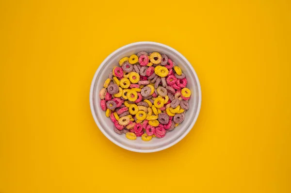 Corn Flakes in Bowl. Colorful Fruity Loops Cereals Background. Top Down View Flat Lay Sweet Muesli. Sweet breakfast in bowl.
