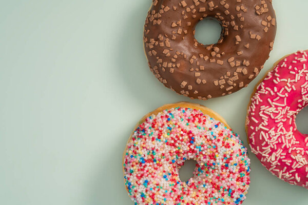 Frosted Donuts. High calorie food. Delicious dessert. Sweet bakery copy space. Delicious colorful dessert
