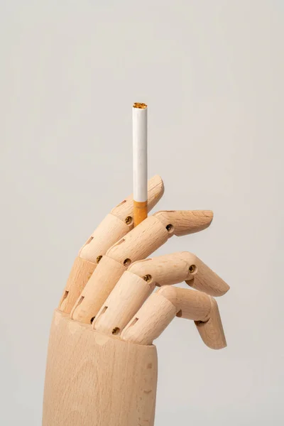 Sarı izole edilmiş arka planda sigarayı işaret eden el ele tutuşmalar. 