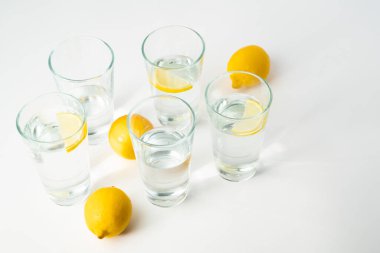 Limonlu su bardakları. Beyaz arka planda soğuk su. Buzlu saf maden suyu. Temiz zemin ile soğuk buzlu su. 