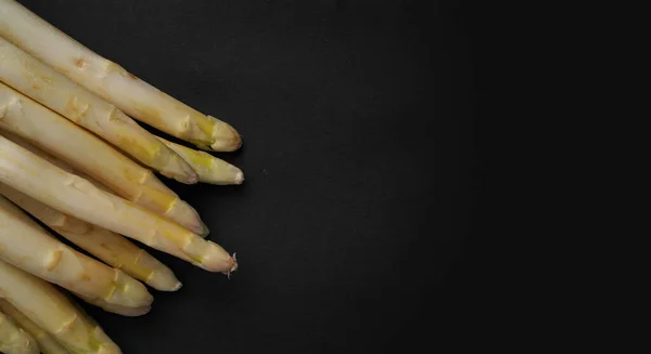 Taze kuşkonmaz sebzeler. Organik taze sağlıklı gıdalarla izole edilmiş siyah bir arka plan..