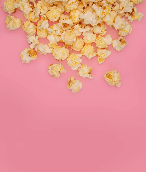 Pembe arka planda patlamış mısır. Tatlı patlamış mısır. Tecrit edilmiş atıştırmalıkların minimum arka planı. Lezzetli yiyecekler düşüyor. Pastel renkli tasarım.
