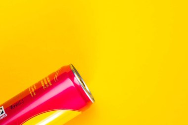Moda ve renkli arka planda pembe soda kutusu. Enerji içeceği reklamı için sarı arka planda izole edilmiş alanı kopyalayın. Bol şekerli tatlı içecekler..