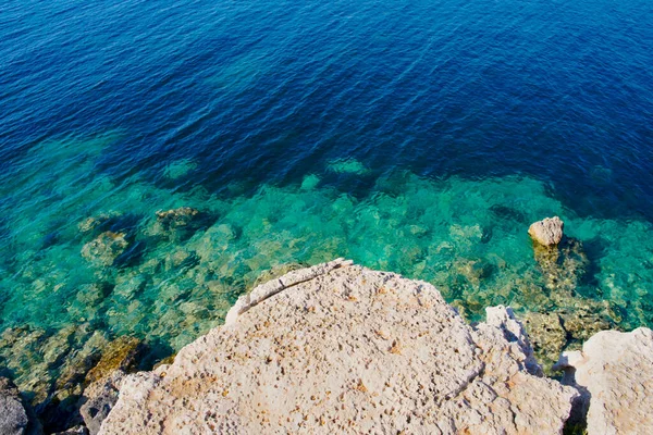 Cliff 'in Kıyısı okyanus suyuna bakıyor. Sahil şeridindeki yüksek kayalıklardan aşağı doğru yukarıdan manzara. 