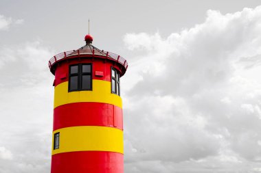 Krummhrn, Niedersachsen - 15 Temmuz 2022: Almanya Pilsum Deniz Feneri, Krummhrn. Sarı ve kırmızı renkli renkli deniz feneri.